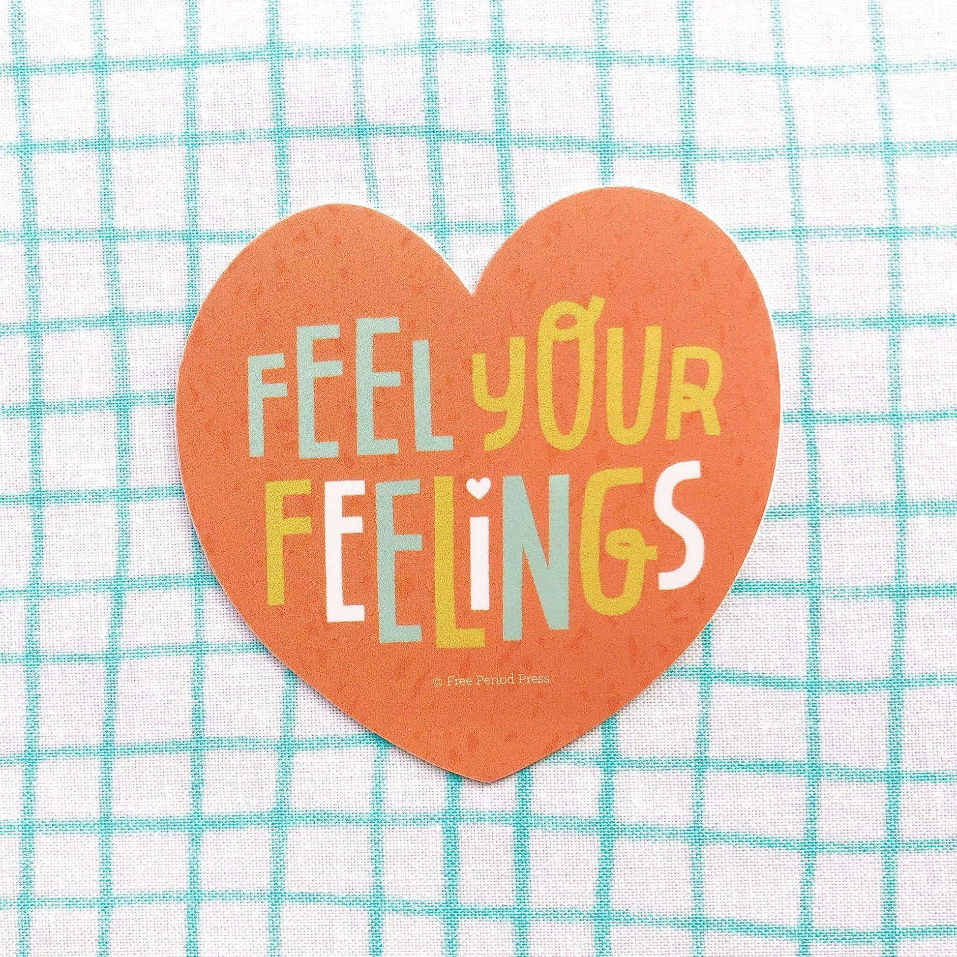 Heart-shaped "Feel Your Feelings" vinyl decal sticker on a teal and white checkered background. Perfect for journaling and journal supplies.