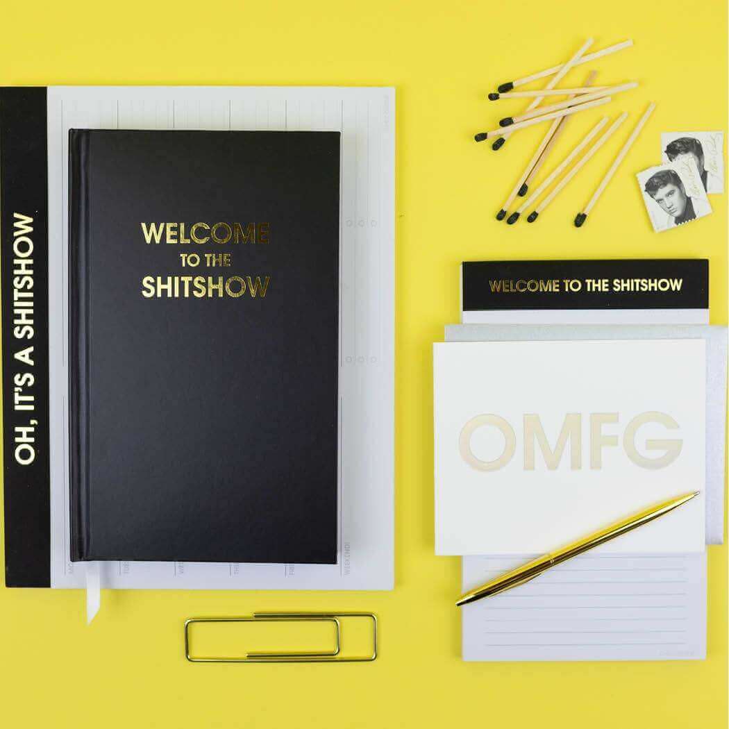 Bold "Welcome to the Shitshow" journal with gold foil cover and journaling supplies, perfect for guided journaling and prompts.