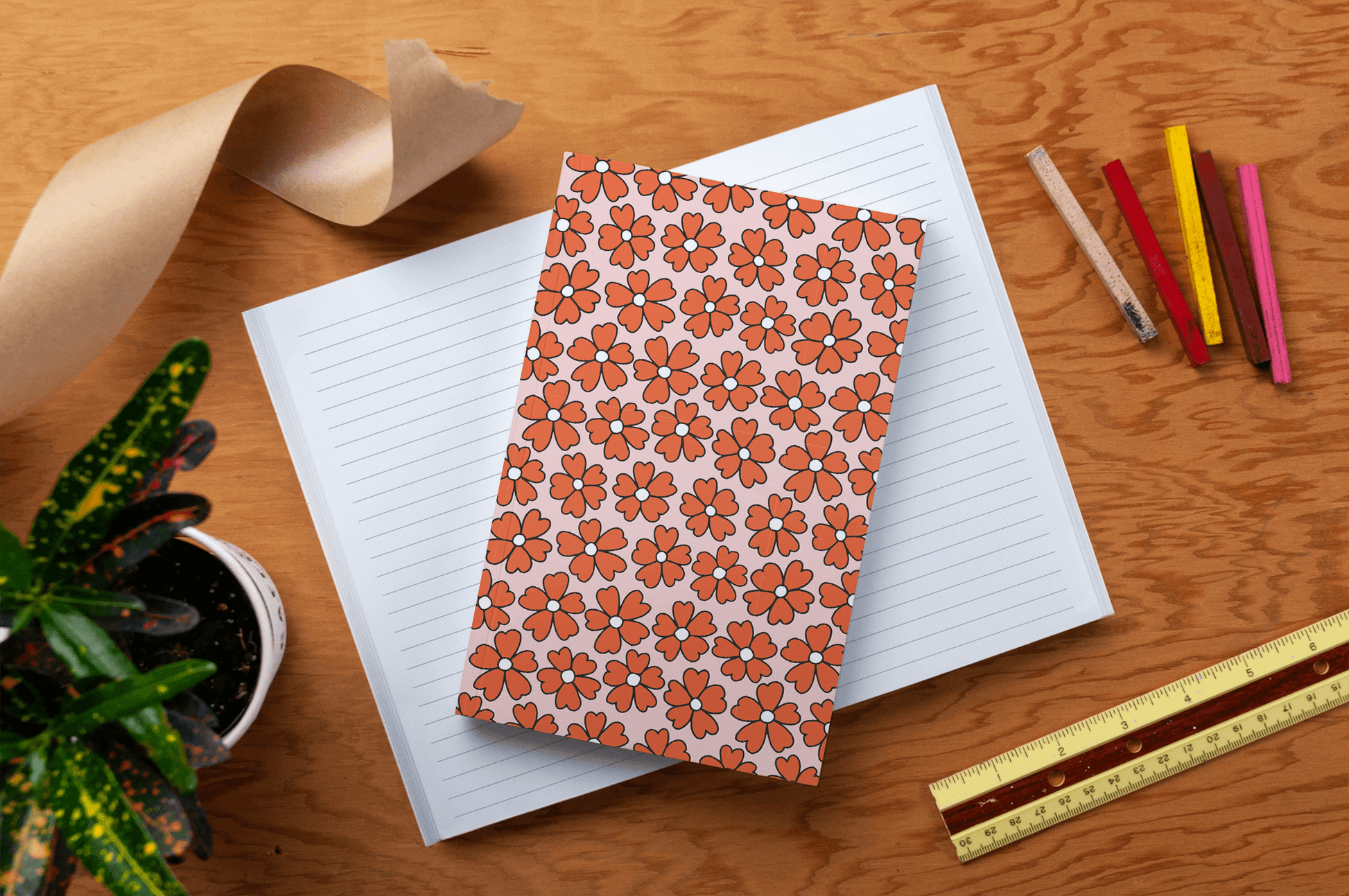 Miss Daisy Classic Layflat Journal Notebook with floral cover on desk surrounded by colorful pens, ruler, and plant, perfect for journaling.