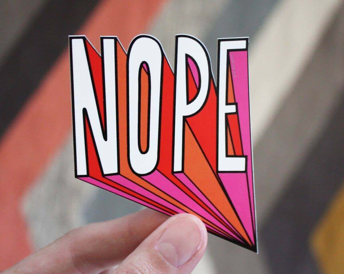 Holding a colorful Nope Vinyl Decal Sticker designed by Katie Daugherty, perfect for journal supplies, journaling, and guided journaling.