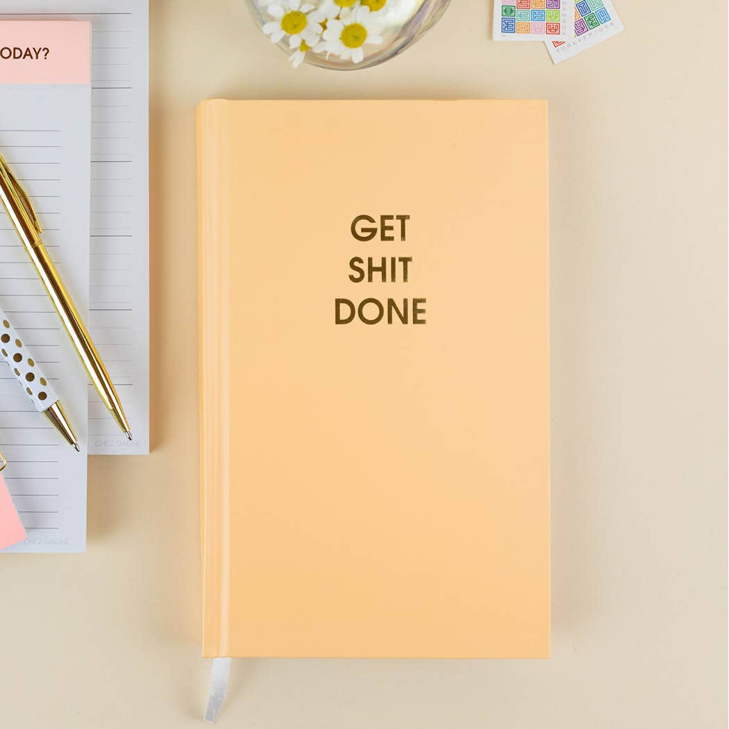 Bright hardcover "Get Shit Done" journal in Mimosa Orange with gold foil print, perfect for achieving goals and journaling motivation.