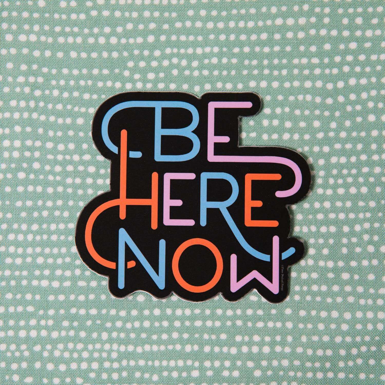 "Colorful Be Here Now vinyl decal sticker on a patterned background for laptops, journals, and more - perfect for journaling and staying present"