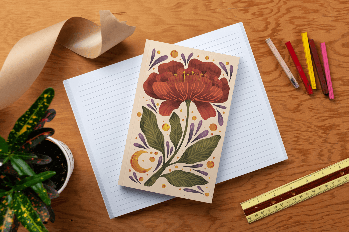 Burgundy Bloom Classic Layflat Journal Notebook open on table with colorful pens, ruler, and plant, ideal for guided journaling and supplies.