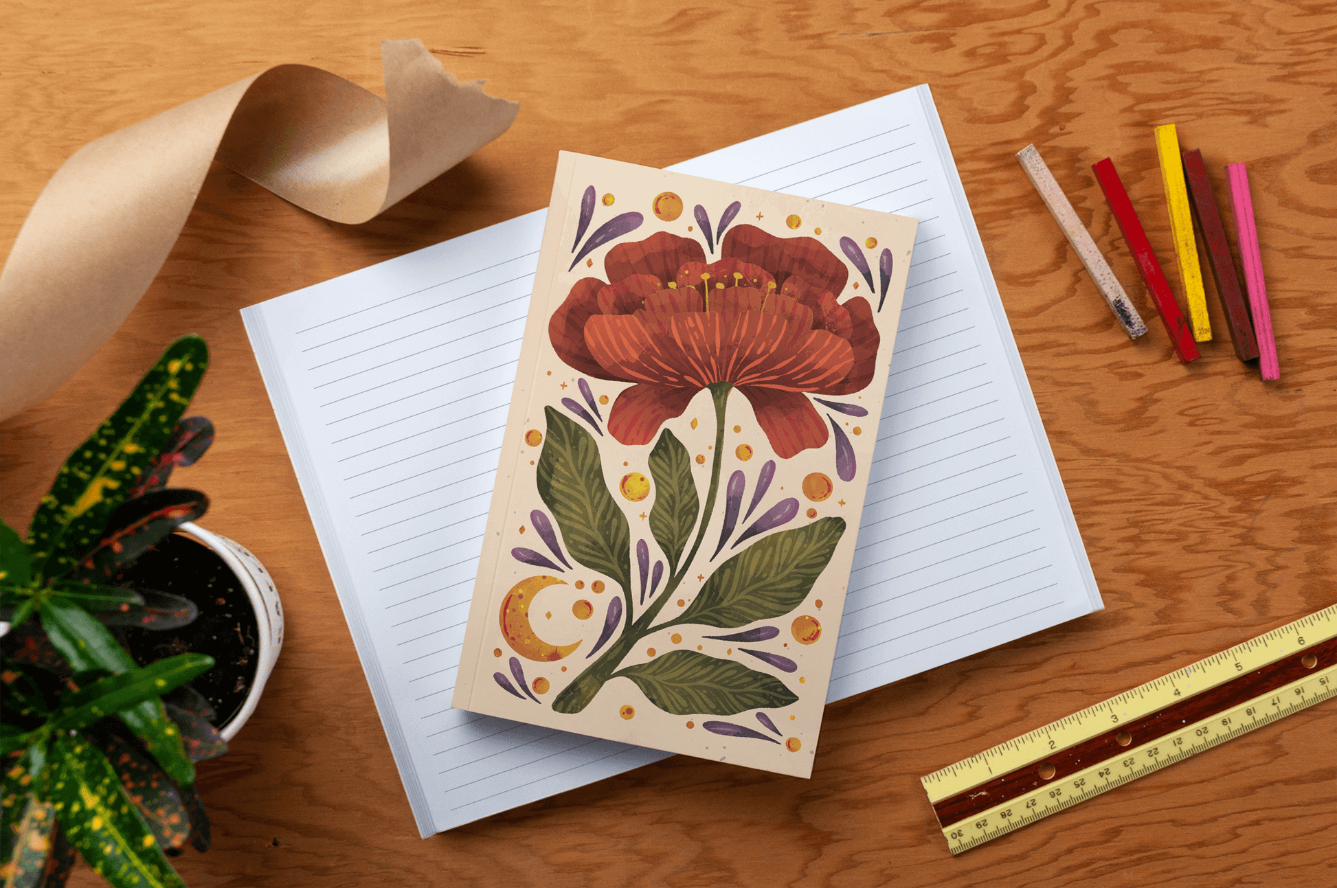 Burgundy Bloom Classic Layflat Journal Notebook open on table with colorful pens, ruler, and plant, ideal for guided journaling and supplies.