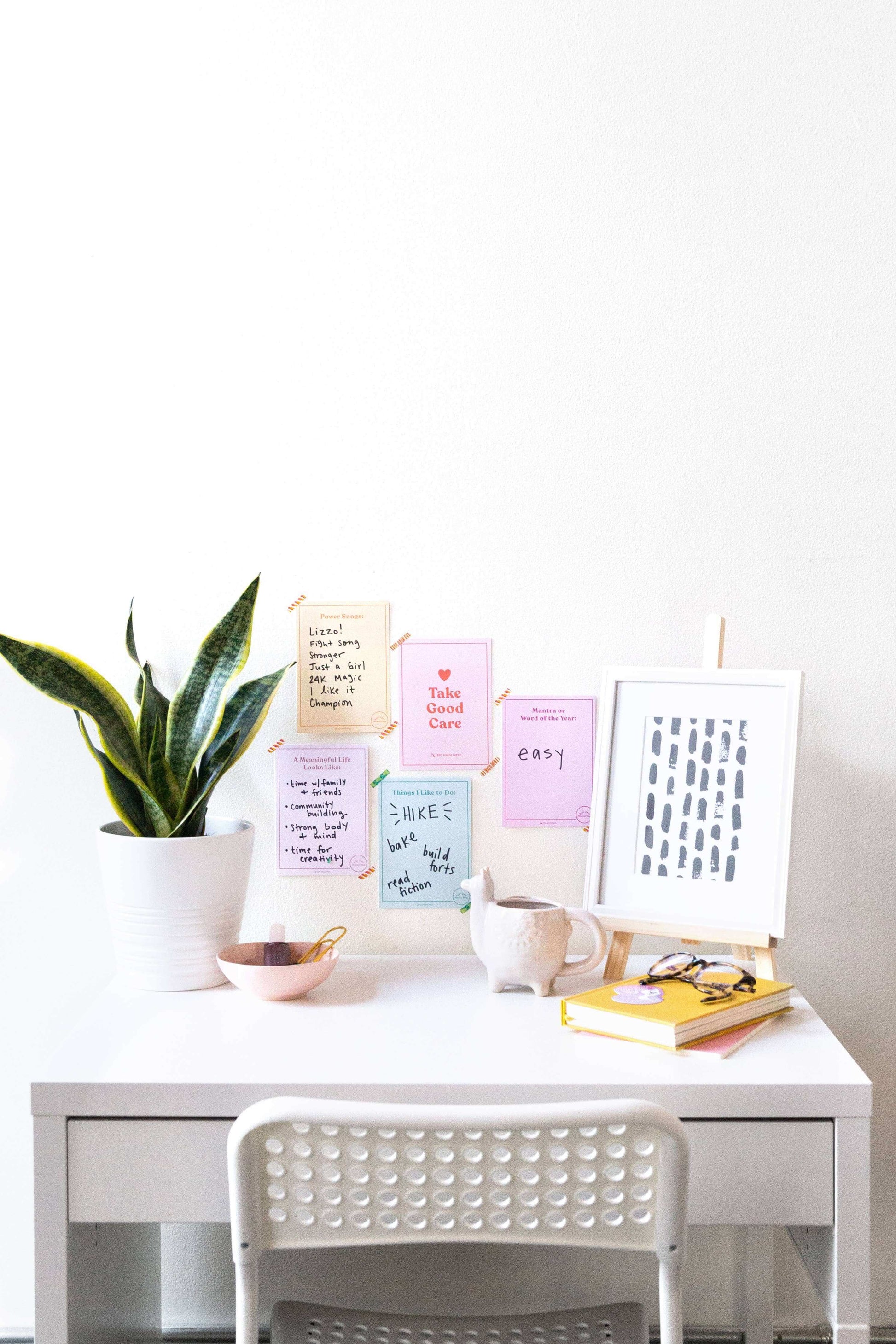 Self-Care Master Plan guide on white desk with journaling supplies, potted plant, and motivational cards in a serene workspace.