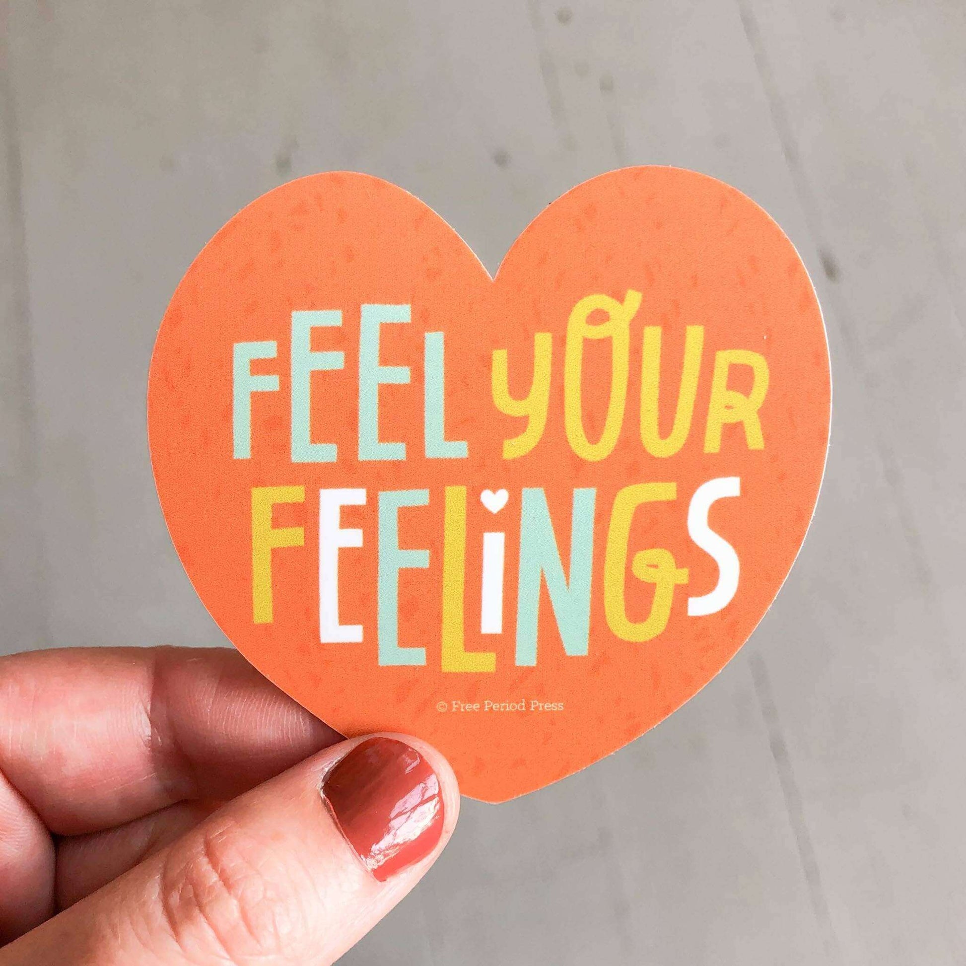 Heart-shaped "Feel Your Feelings" vinyl decal sticker held in hand, perfect for journaling, journal prompts, and guided journaling supplies.