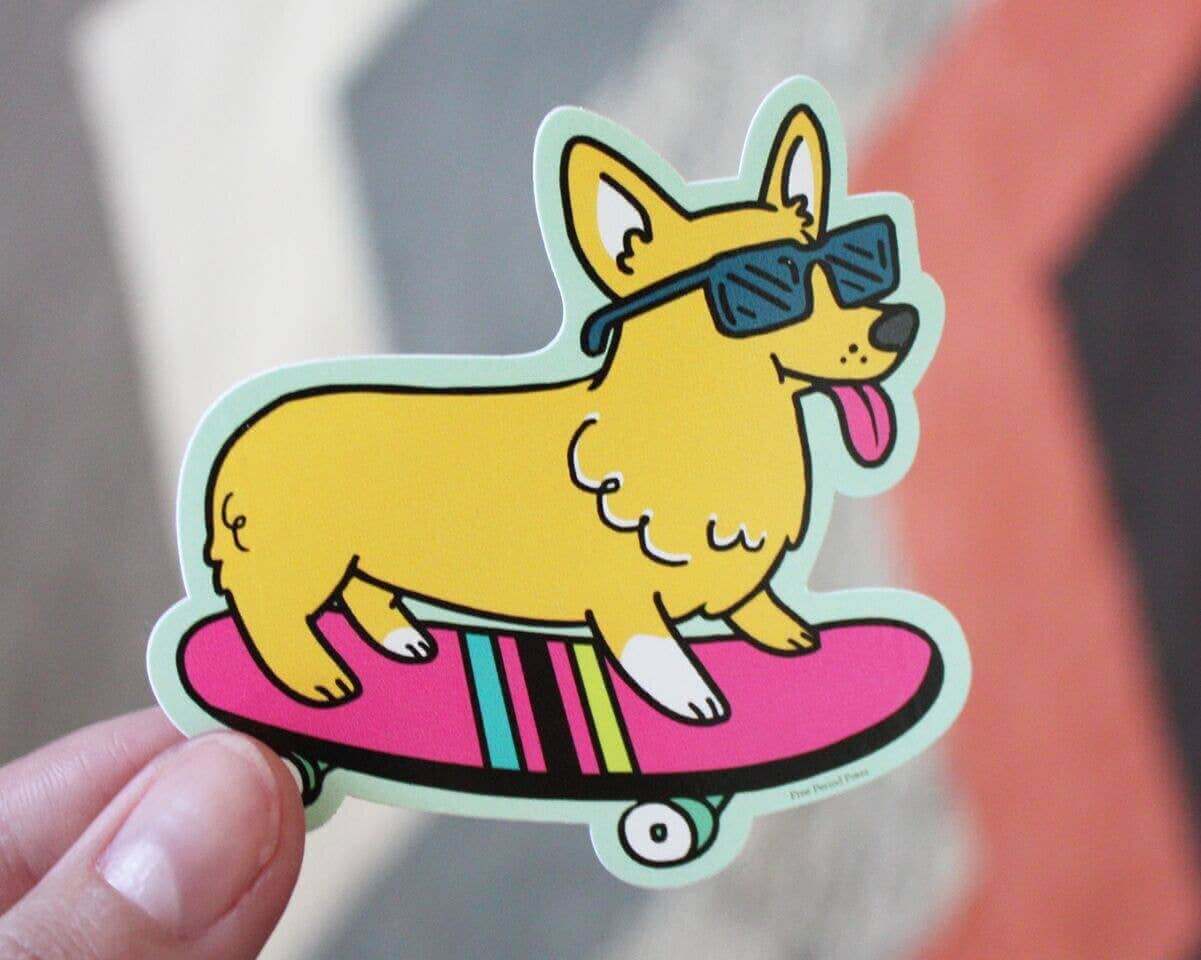 Skateboarding corgi vinyl decal with sunglasses, perfect for journaling supplies and a cool addition to laptops and water bottles.