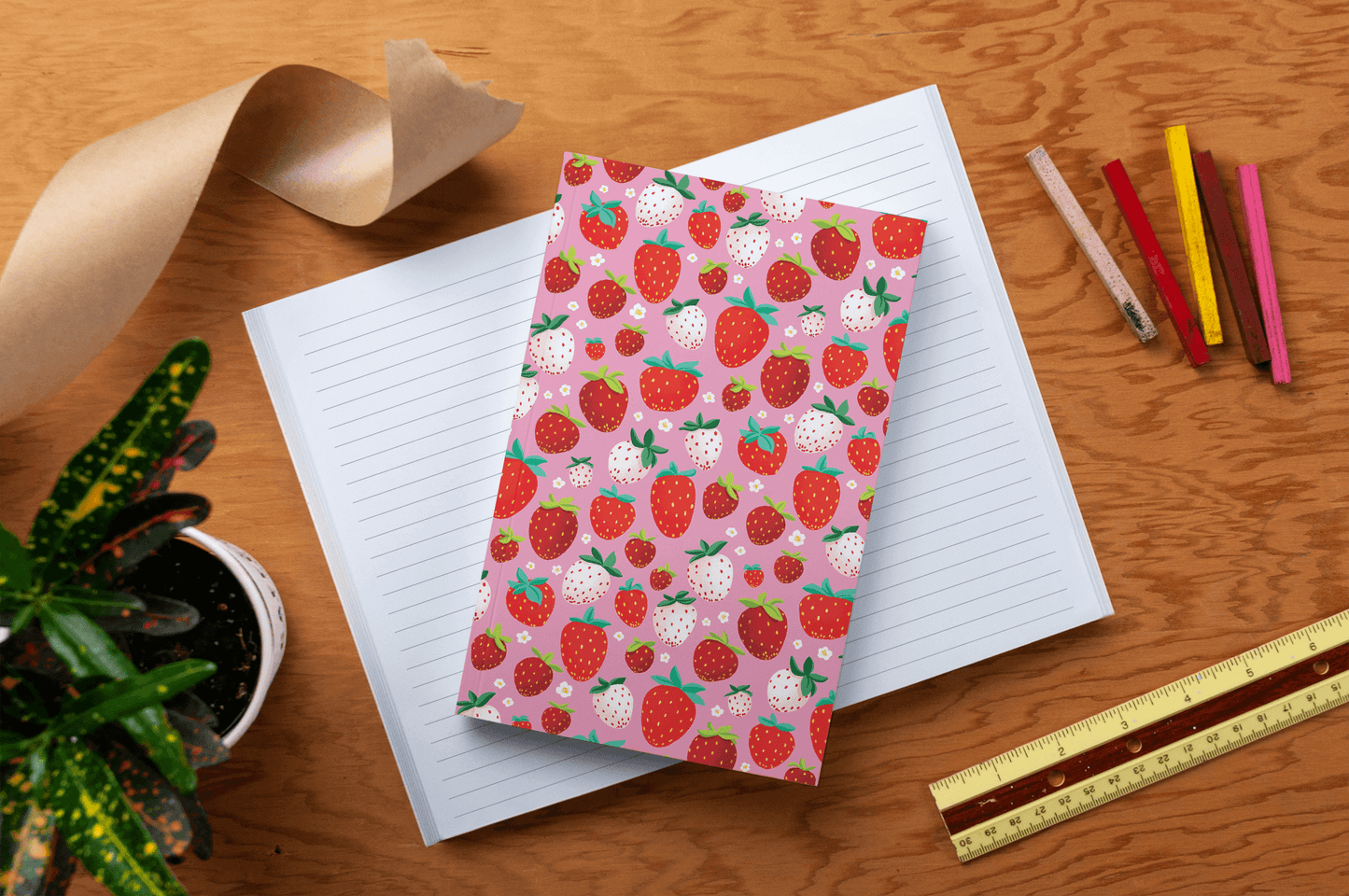 Berrylicious Classic Layflat Journal Notebook with strawberry cover, open lined pages, and journaling supplies on a wooden table