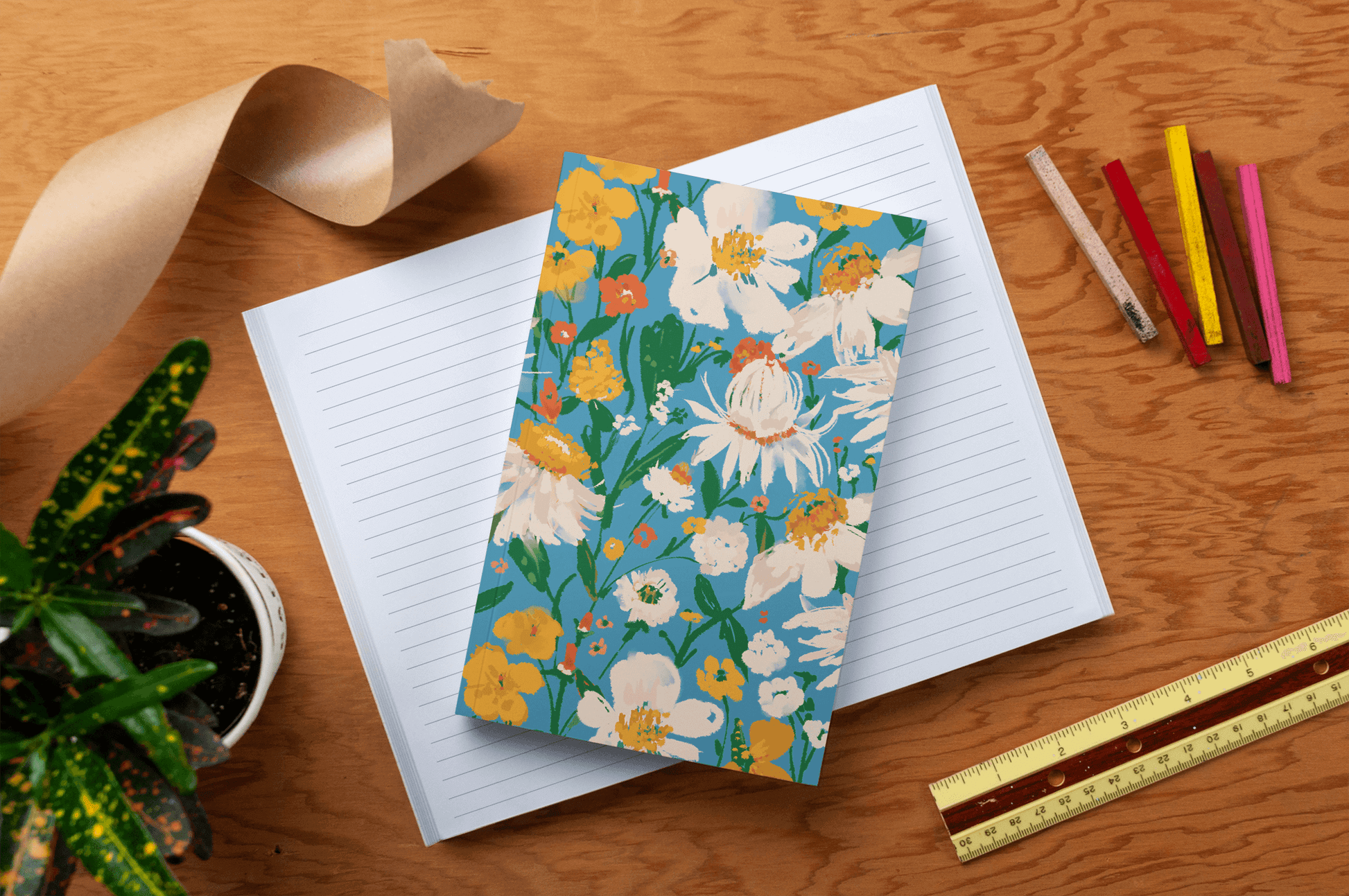 Blue Bouquet Layflat Journal Notebook for smooth journaling, showcasing vibrant floral cover on a desk with open pages, pens, plant, and ruler