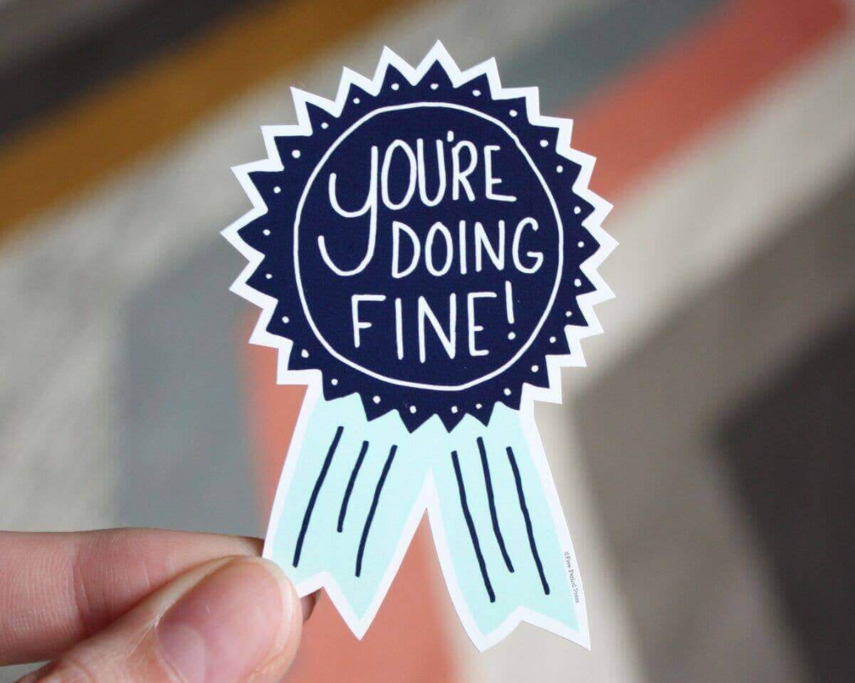 "You're Doing Fine Vinyl Decal Sticker held by hand, perfect for journaling, laptops, water bottles, notebooks, and more."