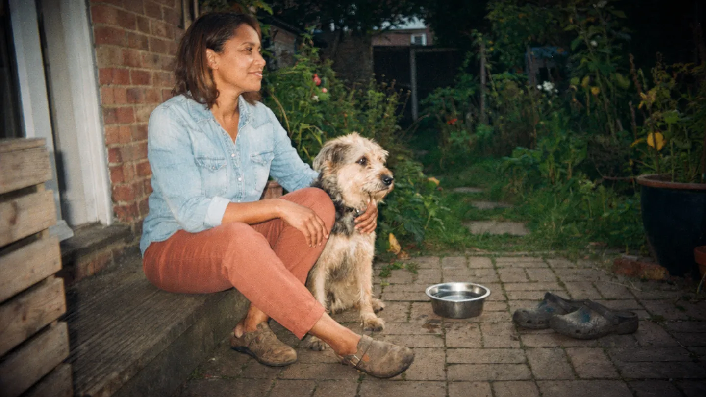 A woman spends a quiet moment on her back step with her dog.